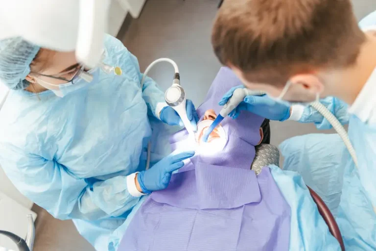 An oral surgeon and nurse performing a dental implant surgery procedure.