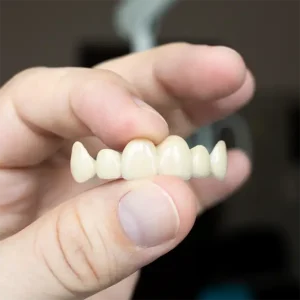 hand holding a dental bridge