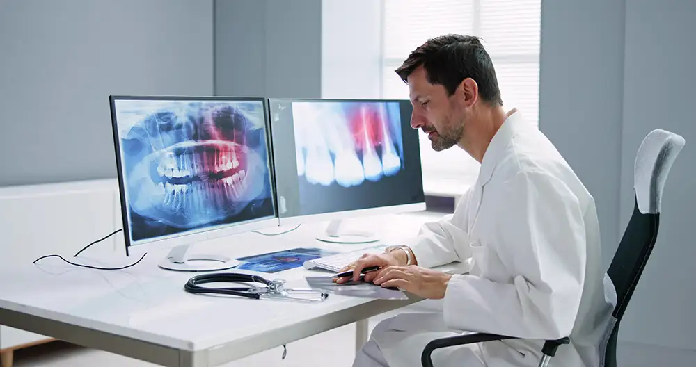 Dentist looking at gum and jaw x-rays